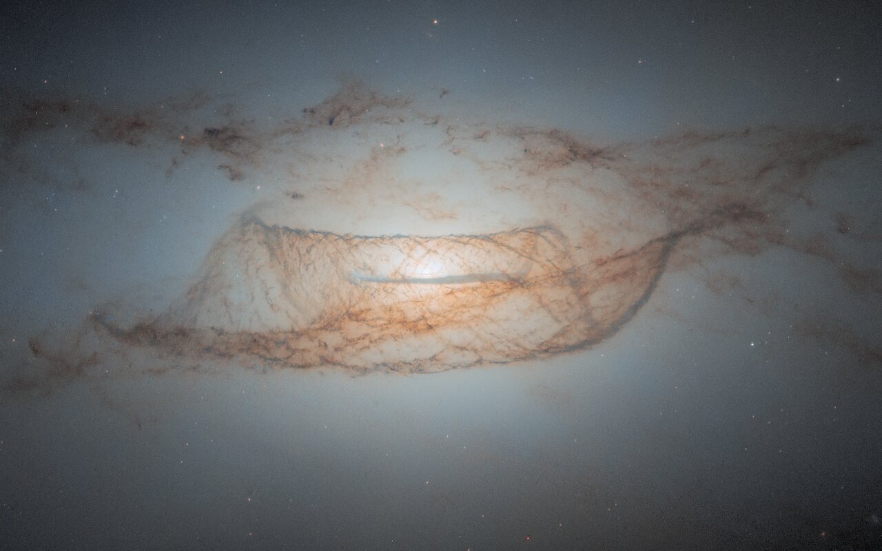 «Hubble» сфотографировал окутанную нитями пыли галактику